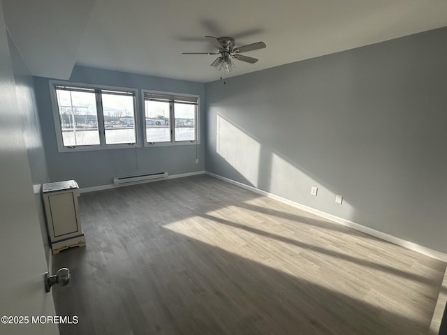 unfurnished room with a baseboard heating unit, baseboards, ceiling fan, and dark wood-style flooring