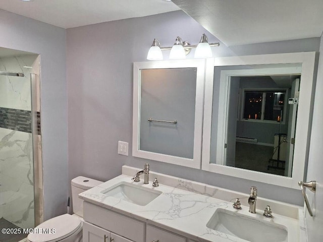 bathroom with a shower stall, toilet, a sink, and double vanity
