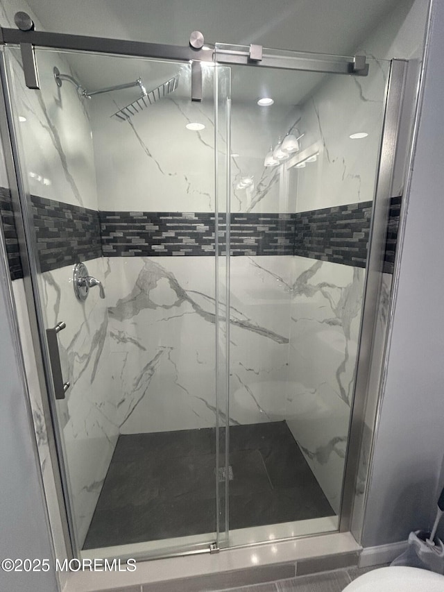 full bath with toilet and a marble finish shower