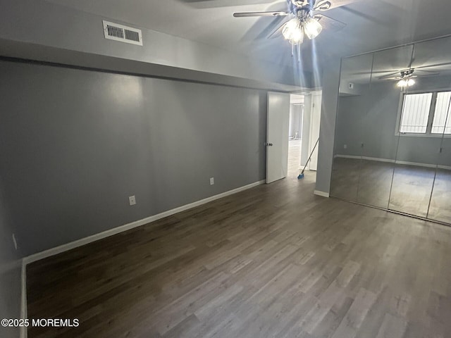 basement featuring baseboards, a ceiling fan, wood finished floors, and visible vents