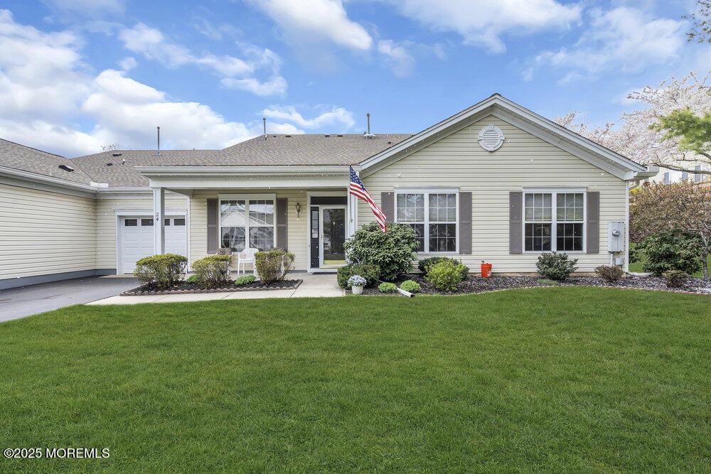 single story home with driveway, a front yard, and a garage