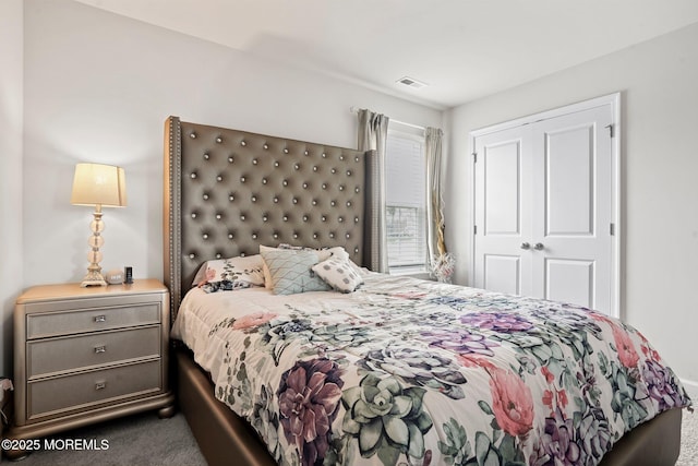 bedroom with a closet, visible vents, and carpet flooring