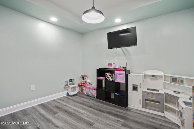 recreation room featuring baseboards, wood finished floors, and recessed lighting