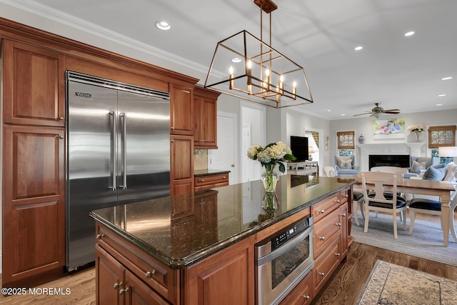 15 Monmouth Ave, Rumson, NJ 07760 - kitchen with stainless steel built in refrigerator, recessed lighting, a fireplace, brown cabinets, and a kitchen island