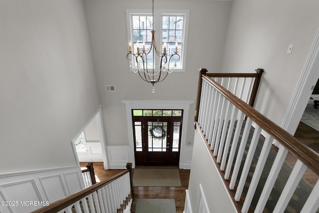 15 Monmouth Ave, Rumson, NJ 07760 - entrance foyer featuring a chandelier, a high ceiling, a decorative wall, wood finished floors, and wainscoting