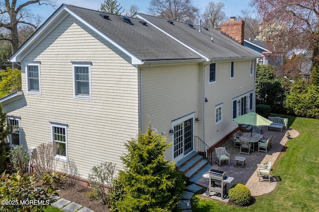 15 Monmouth Ave, Rumson, NJ 07760 - rear view of house featuring entry steps, a patio area, a chimney, a yard, and a shingled roof