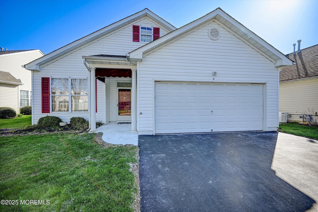 view of front facade with a front lawn, aphalt driveway, and an attached garage