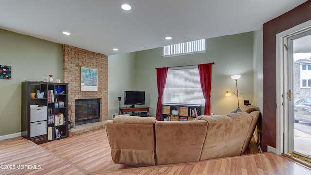 living room with recessed lighting, a fireplace, light wood-style floors, and baseboards