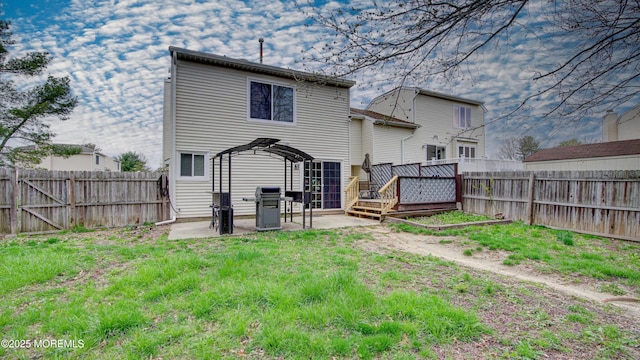back of property featuring a patio, a fenced backyard, a deck, and a lawn