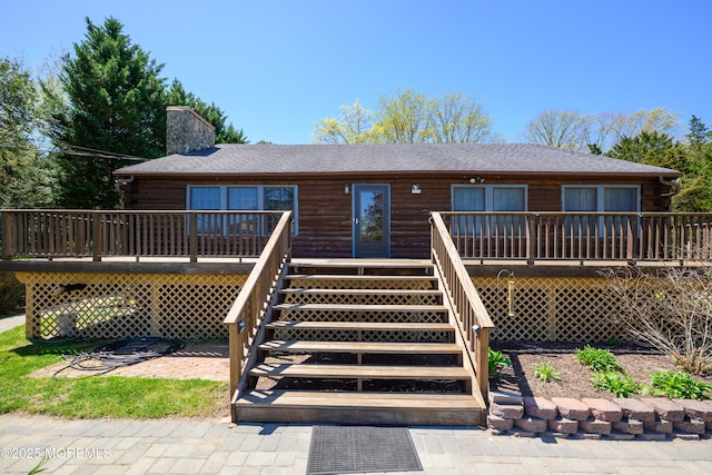 3297 Ridgeway Rd, Manchester, NJ 08759 - back of house with a shingled roof, log exterior, a chimney, and a deck
