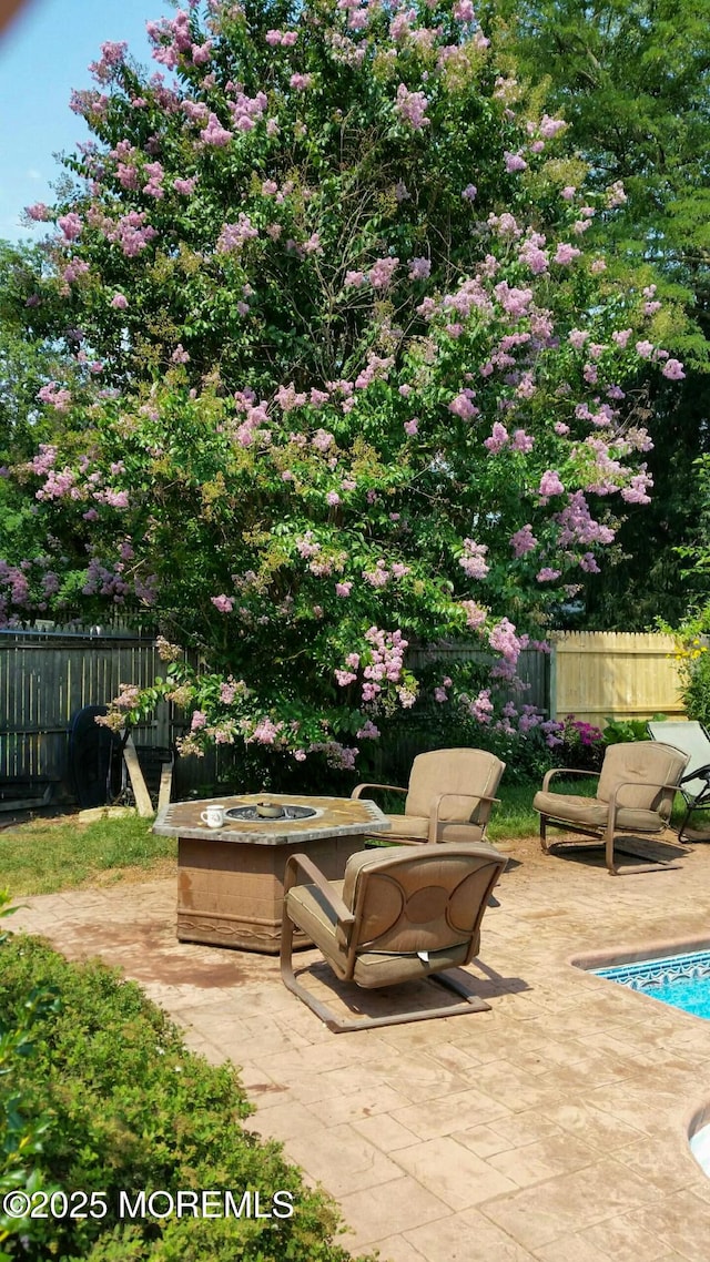 view of patio featuring a fenced in pool, fence, and an outdoor fire pit