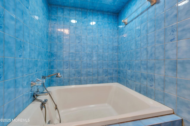 bathroom featuring a bathing tub and tile walls