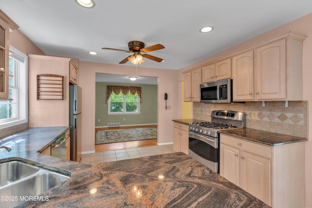 kitchen with stainless steel appliances, visible vents, decorative backsplash, and a sink