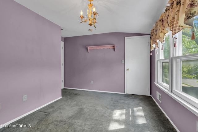 interior space with baseboards, vaulted ceiling, a chandelier, and visible vents