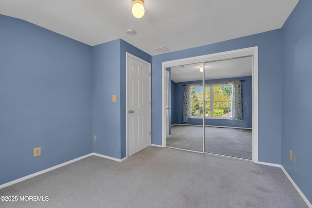 unfurnished bedroom with baseboards, carpet, and a closet