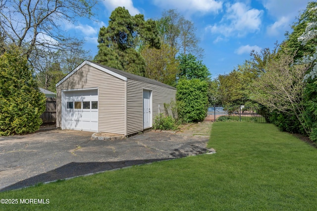 detached garage with fence and driveway