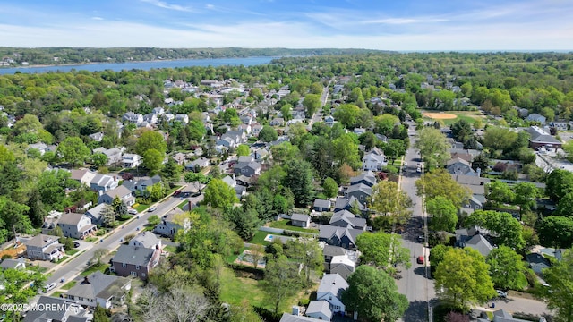 bird's eye view featuring a wooded view, a water view, and a residential view