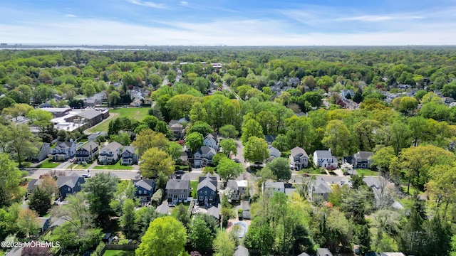 drone / aerial view featuring a residential view and a forest view