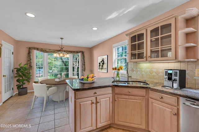 kitchen featuring backsplash, a sink, a peninsula, and light brown cabinetry