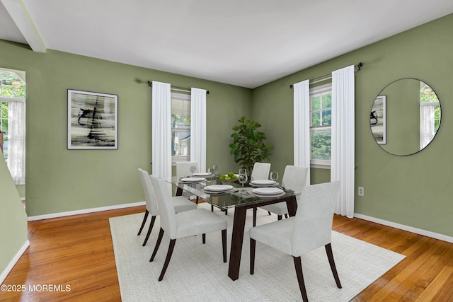 dining room featuring plenty of natural light, light wood finished floors, and baseboards