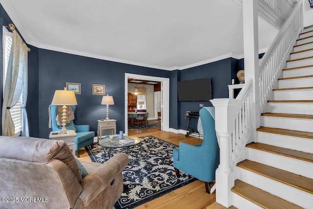 living area with ornamental molding, baseboards, wood finished floors, and stairs