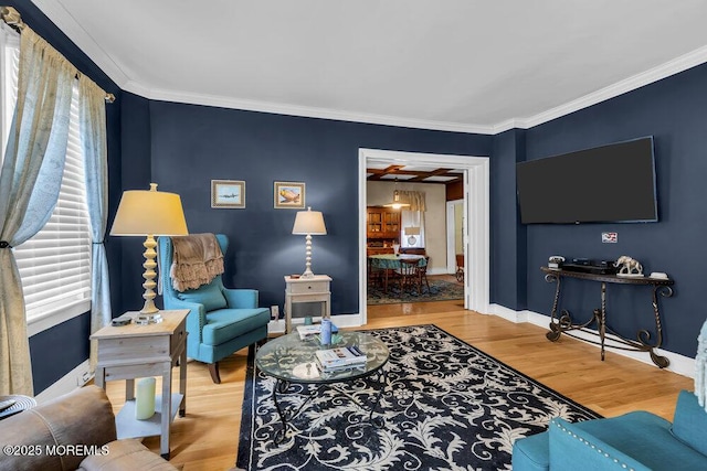 living room featuring baseboards, crown molding, and wood finished floors