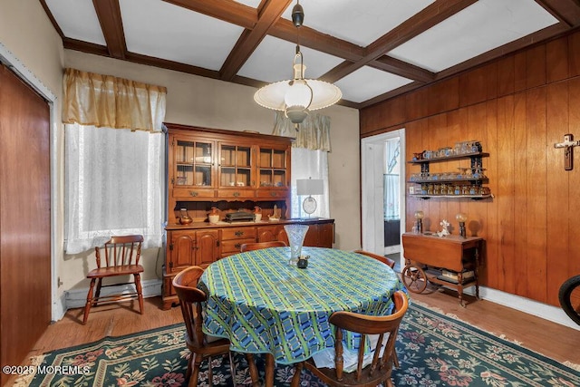 dining space featuring a baseboard heating unit, light wood-type flooring, wood walls, beam ceiling, and coffered ceiling