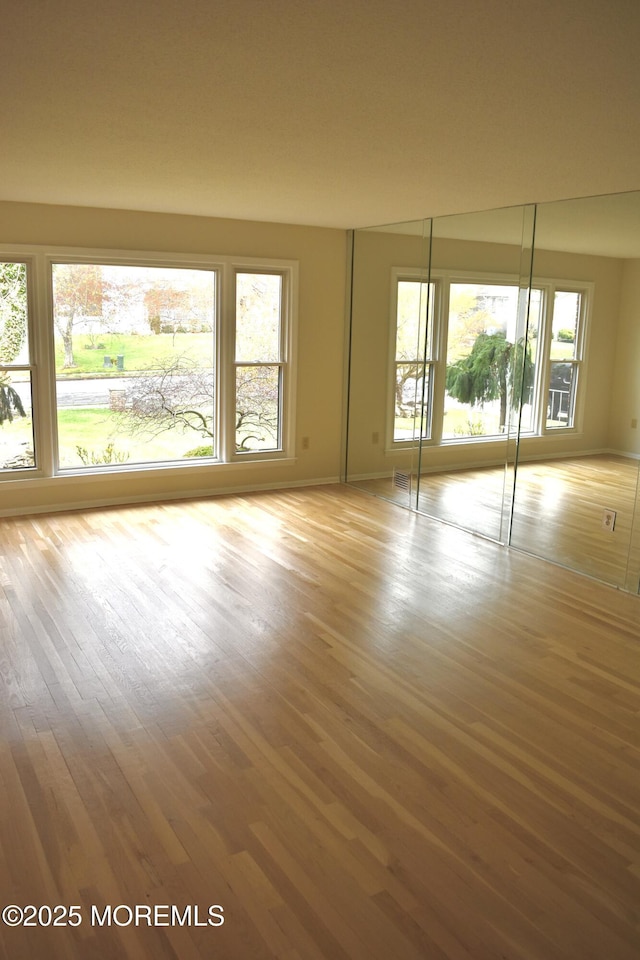 unfurnished room with wood finished floors and baseboards