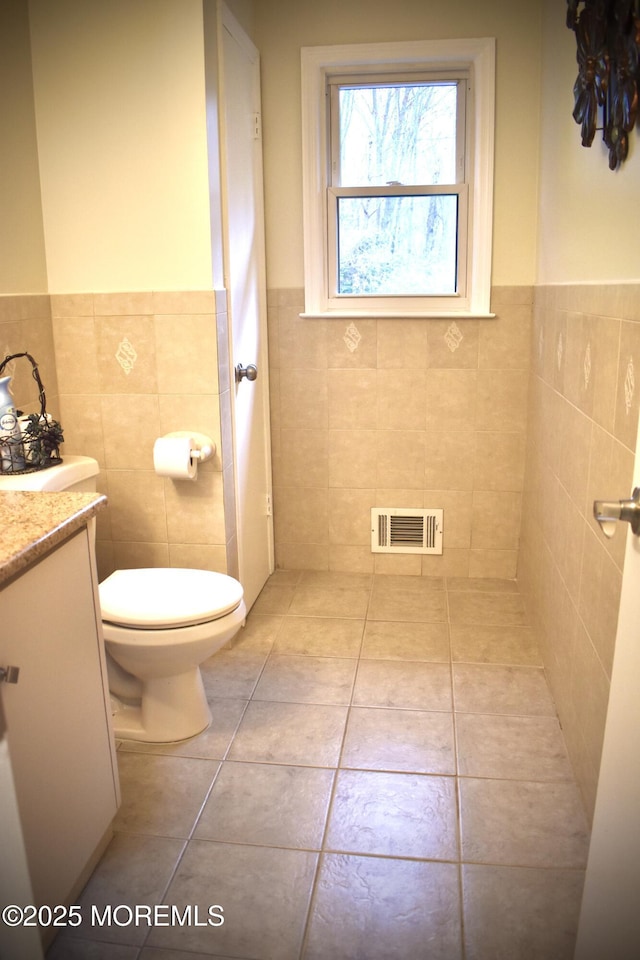 bathroom featuring visible vents, tile walls, a wainscoted wall, and tile patterned floors