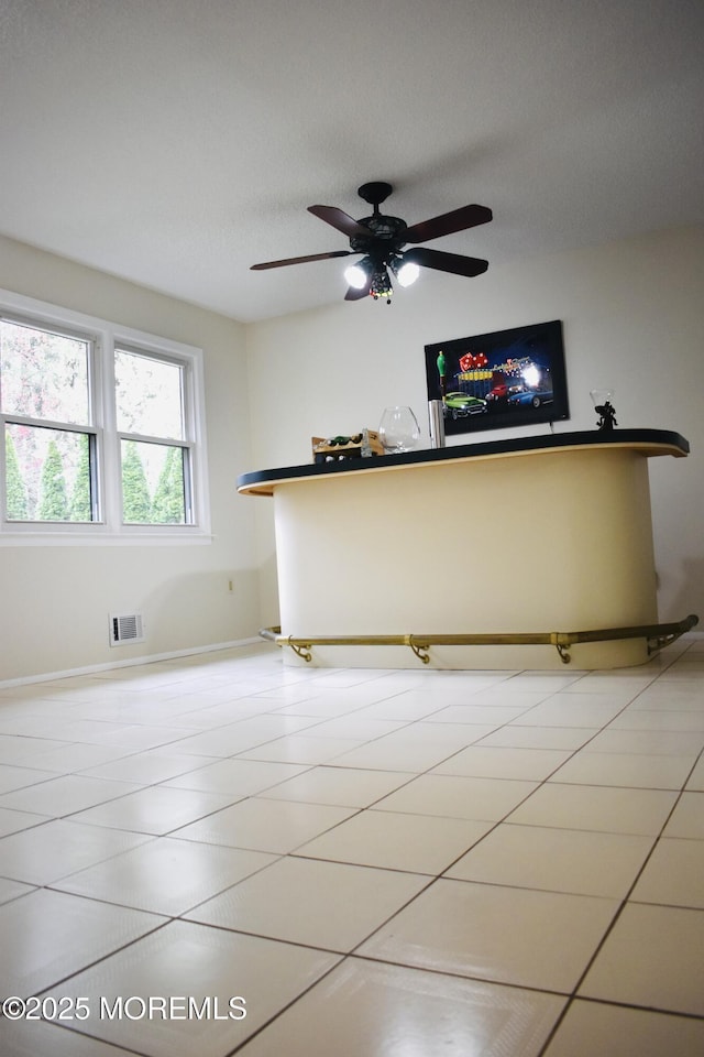 unfurnished room featuring visible vents, baseboards, and ceiling fan