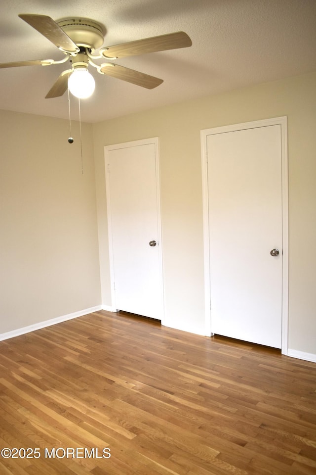 unfurnished bedroom with baseboards, light wood finished floors, and a ceiling fan