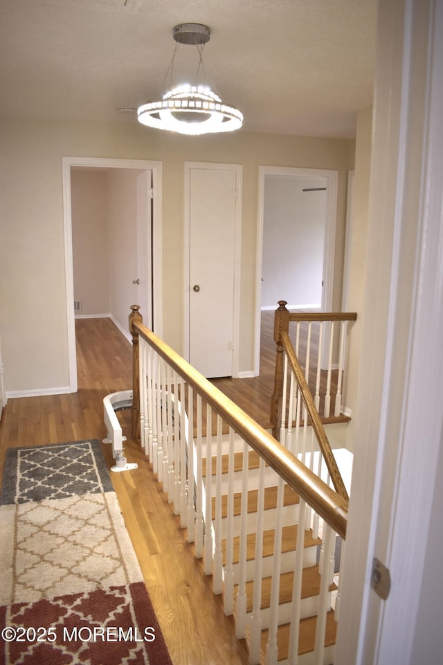staircase with baseboards and wood finished floors