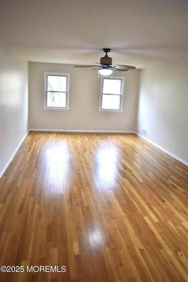 unfurnished room featuring ceiling fan, hardwood / wood-style floors, and baseboards