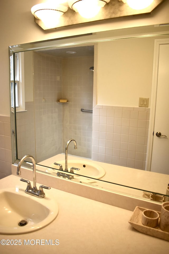 bathroom featuring a shower, tile walls, and a sink