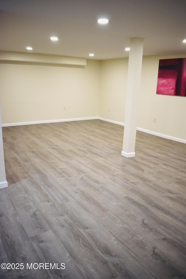 finished below grade area featuring recessed lighting, baseboards, and wood finished floors