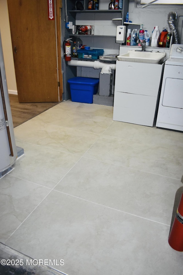 washroom with a sink, laundry area, and washing machine and clothes dryer