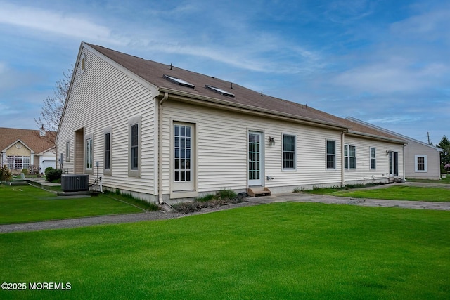 exterior space featuring central AC unit and a lawn