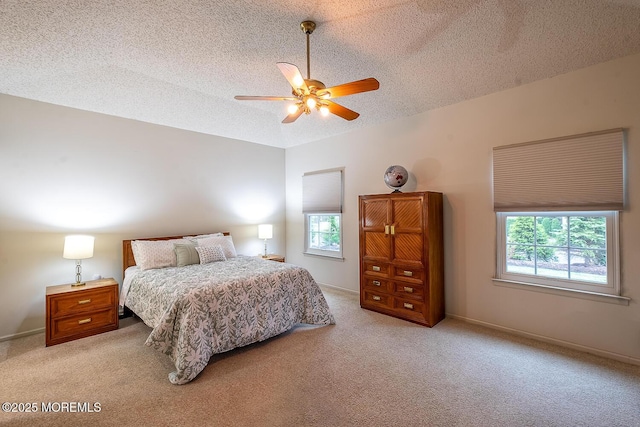 bedroom with light carpet, multiple windows, a textured ceiling, and a ceiling fan