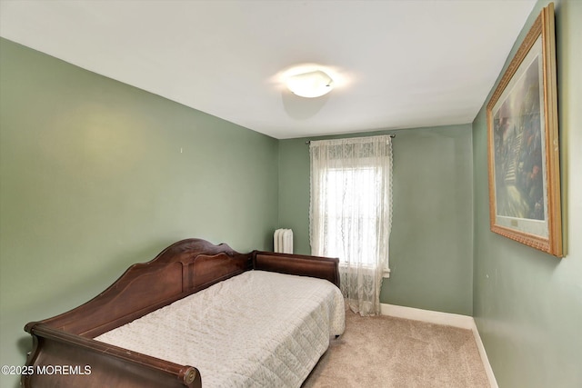 bedroom featuring radiator heating unit, baseboards, and carpet floors
