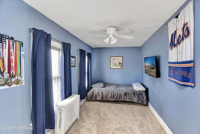 carpeted bedroom featuring radiator heating unit, baseboards, and ceiling fan