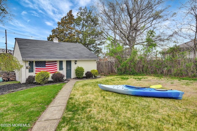 exterior space featuring a front yard, fence, and a chimney