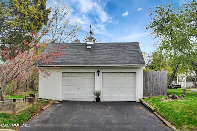 detached garage featuring fence