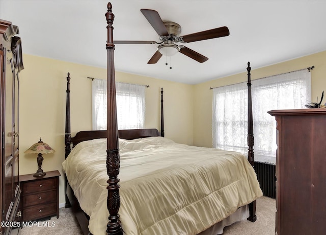 carpeted bedroom with multiple windows and a ceiling fan
