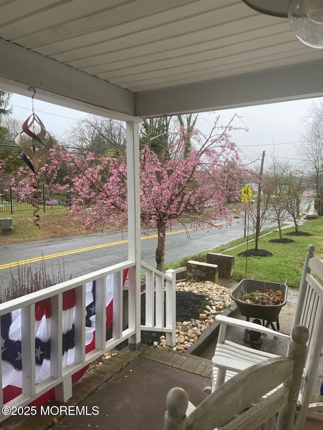 view of patio / terrace featuring a porch and fence