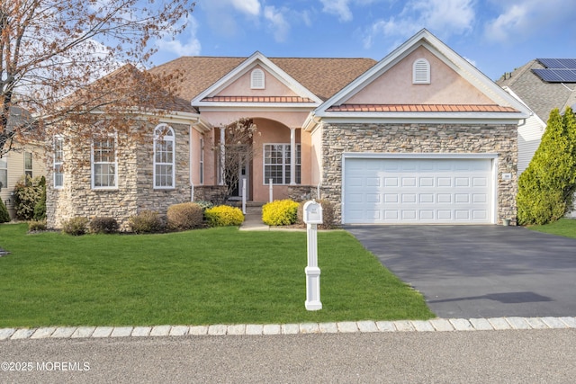 view of front facade with a front lawn, stucco siding, stone siding, and aphalt driveway