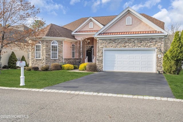 view of front of home featuring aphalt driveway, stucco siding, stone siding, and a front yard