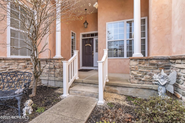 property entrance with stone siding and stucco siding