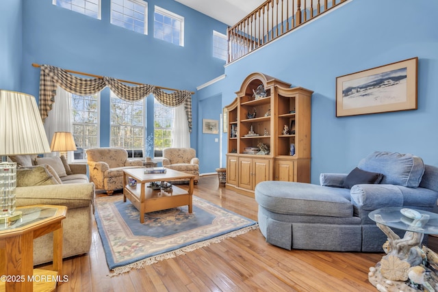living room with a towering ceiling and hardwood / wood-style flooring