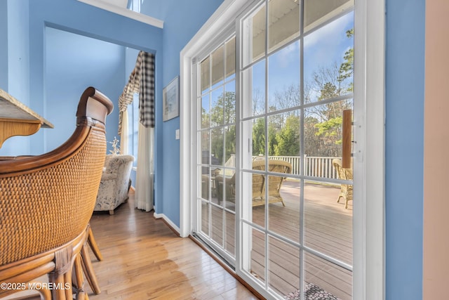 doorway featuring wood finished floors and baseboards
