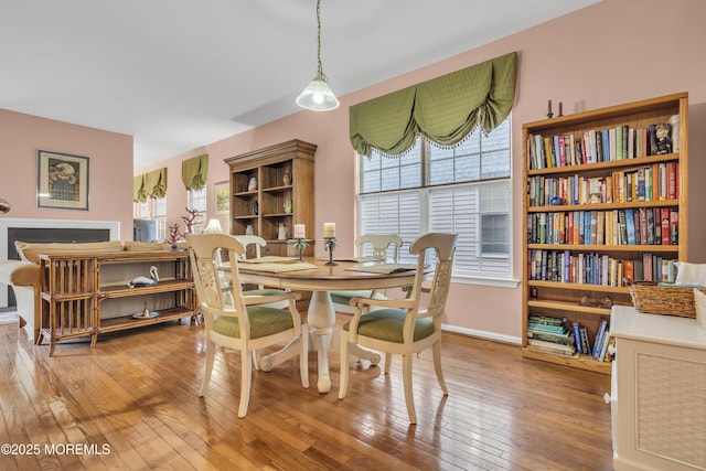 dining area with wood-type flooring and baseboards